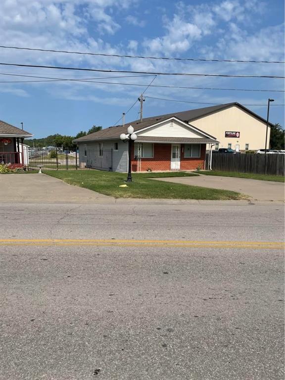 view of front of property with brick siding, a front yard, and fence