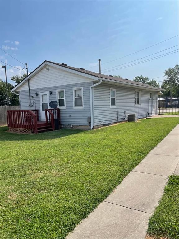 back of house featuring cooling unit, a wooden deck, a yard, and fence