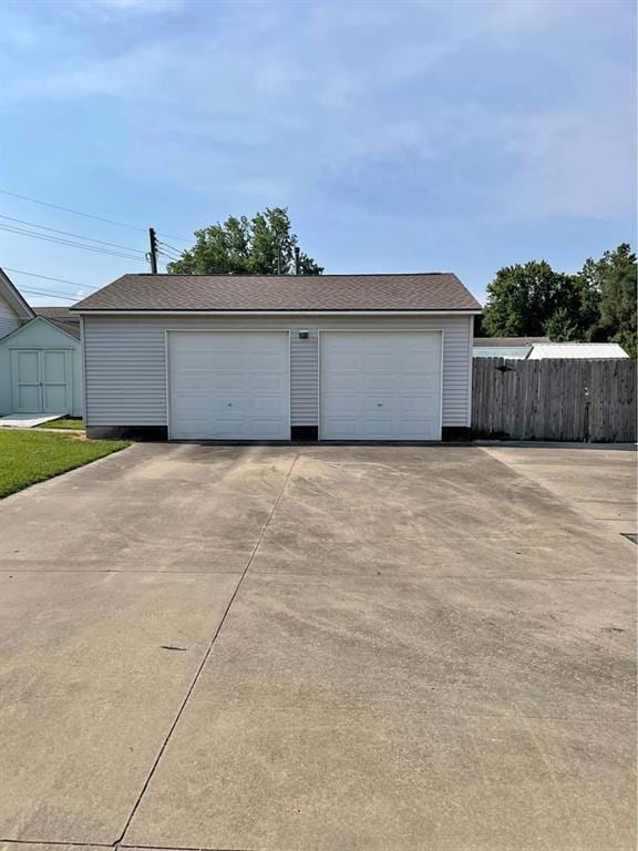 detached garage featuring fence