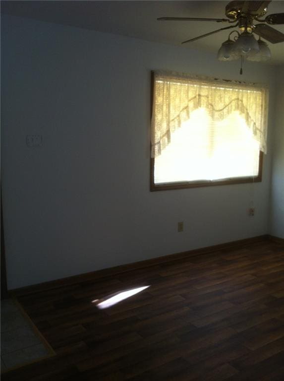 empty room featuring dark wood-style flooring and ceiling fan