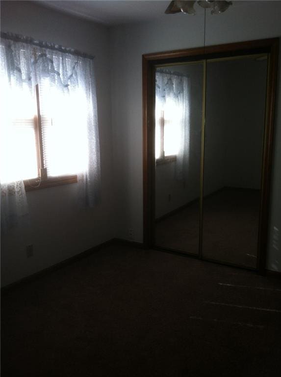 unfurnished bedroom featuring a closet and multiple windows