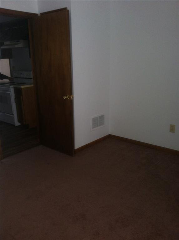 unfurnished dining area with baseboards, visible vents, and carpet floors