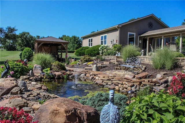 exterior space featuring a gazebo and a small pond