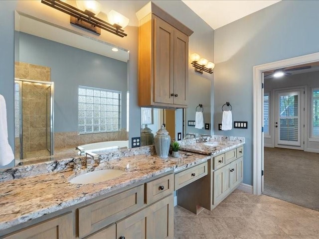 full bath featuring a stall shower, a washtub, a sink, double vanity, and baseboards