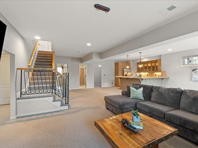 living room featuring stairway, recessed lighting, light colored carpet, and visible vents