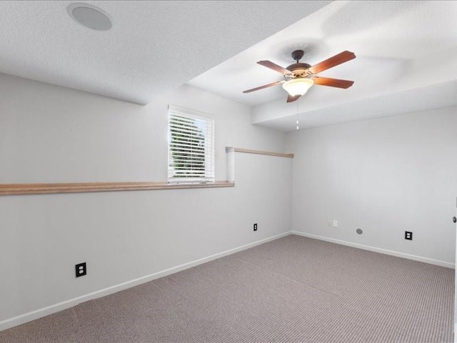 empty room featuring baseboards, a textured ceiling, a ceiling fan, and carpet