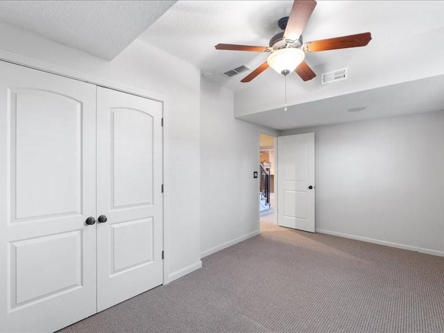 unfurnished bedroom featuring baseboards, visible vents, carpet floors, and a textured ceiling