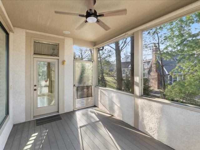 unfurnished sunroom featuring visible vents and ceiling fan