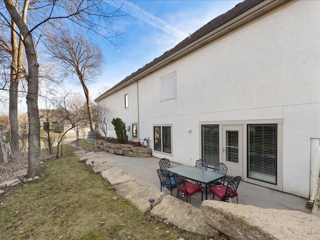 rear view of property with a patio and stucco siding