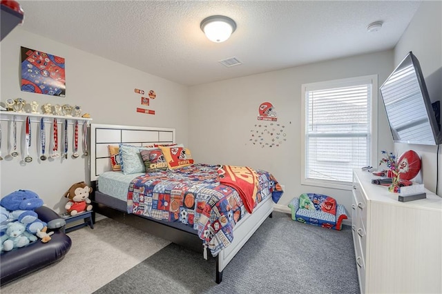 bedroom featuring a textured ceiling and dark carpet