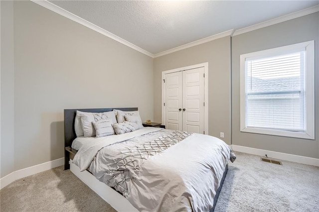 carpeted bedroom featuring crown molding, a closet, and a textured ceiling