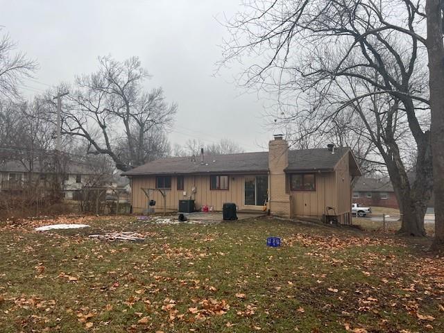 rear view of house with a yard and central air condition unit