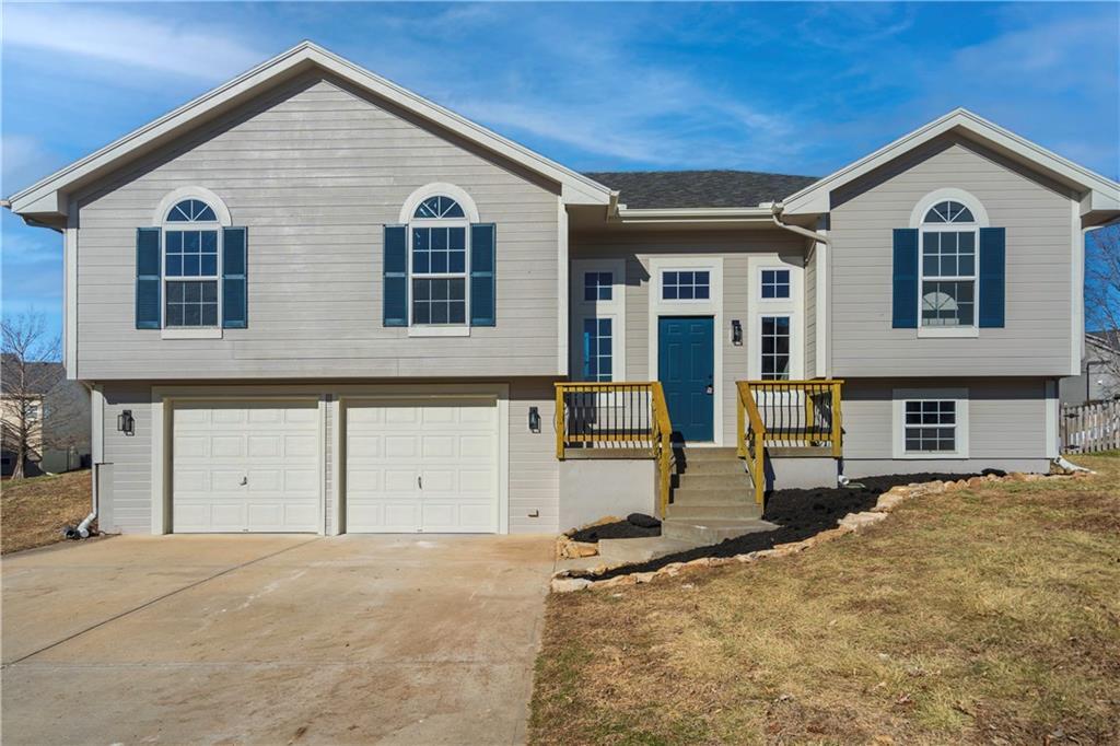 split foyer home featuring a garage and a front lawn