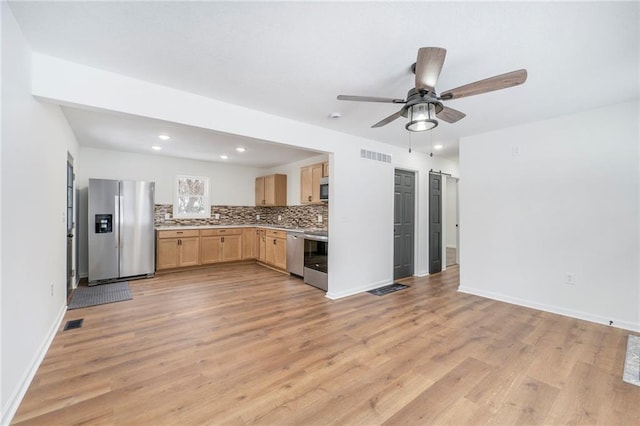 kitchen featuring light wood-type flooring, tasteful backsplash, ceiling fan, appliances with stainless steel finishes, and light brown cabinets