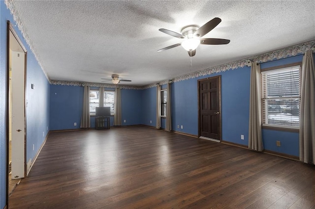 spare room featuring dark wood-type flooring, a textured ceiling, and ceiling fan