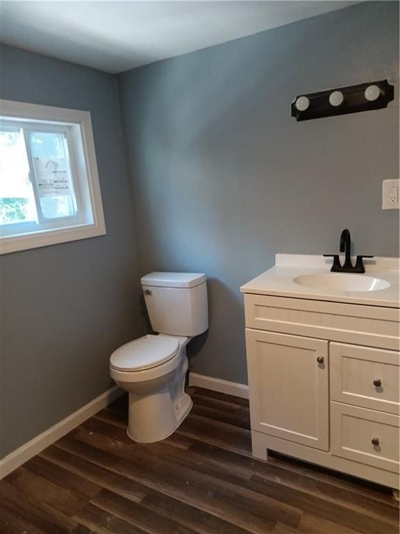 3731 College Ave, Kansas City, MO 64128 - bathroom featuring vanity, wood-type flooring, and toilet