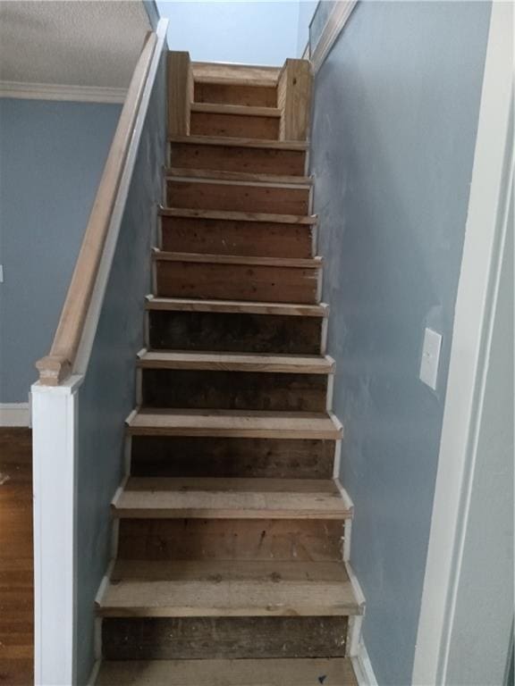 3731 College Ave, Kansas City, MO 64128 - stairway featuring ornamental molding, hardwood / wood-style floors, and a textured ceiling