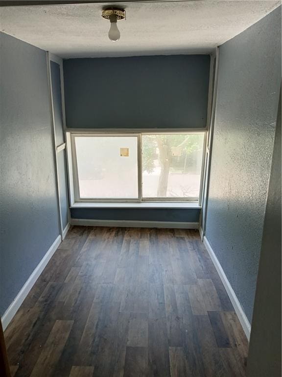 3731 College Ave, Kansas City, MO 64128 - spare room featuring dark wood-type flooring and a textured ceiling