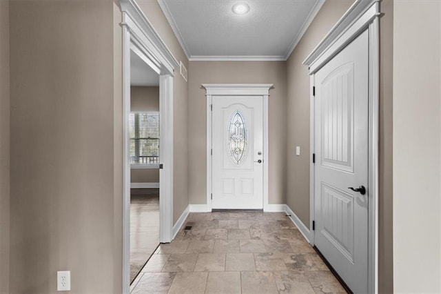 foyer entrance featuring visible vents, baseboards, a textured ceiling, and crown molding