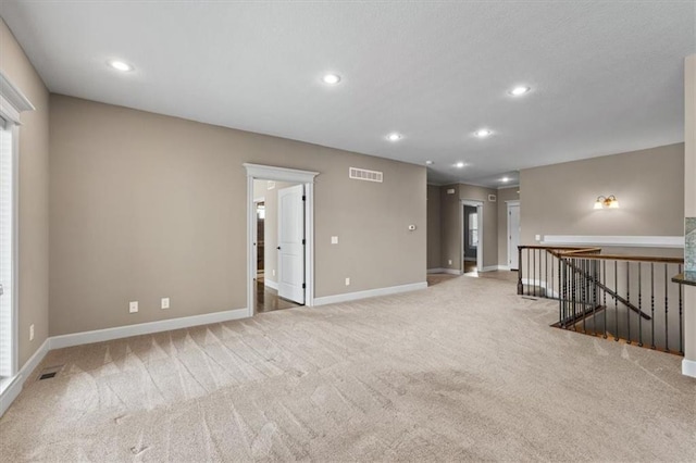 empty room featuring carpet flooring, recessed lighting, visible vents, and baseboards