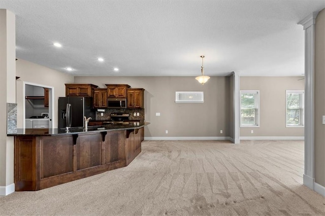 kitchen with brown cabinets, appliances with stainless steel finishes, a kitchen bar, light colored carpet, and tasteful backsplash