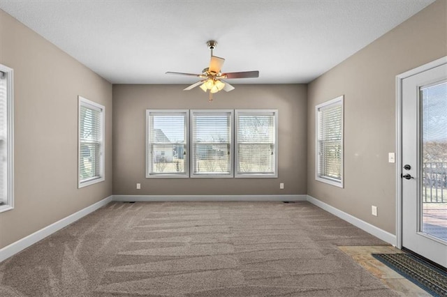 carpeted spare room with baseboards and ceiling fan