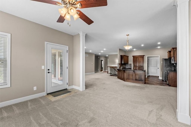 unfurnished living room featuring recessed lighting, carpet floors, decorative columns, baseboards, and ceiling fan