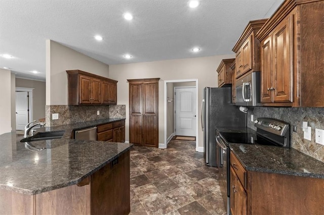 kitchen with a sink, appliances with stainless steel finishes, a peninsula, decorative backsplash, and baseboards