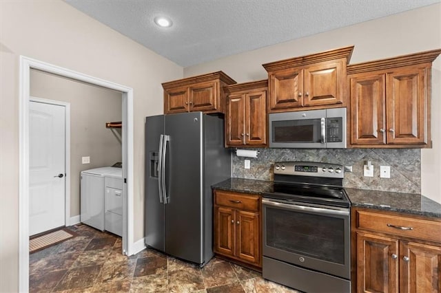 kitchen featuring washing machine and clothes dryer, brown cabinets, tasteful backsplash, and stainless steel appliances