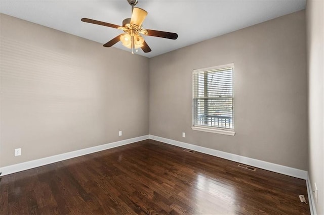 spare room with wood finished floors, visible vents, baseboards, and ceiling fan