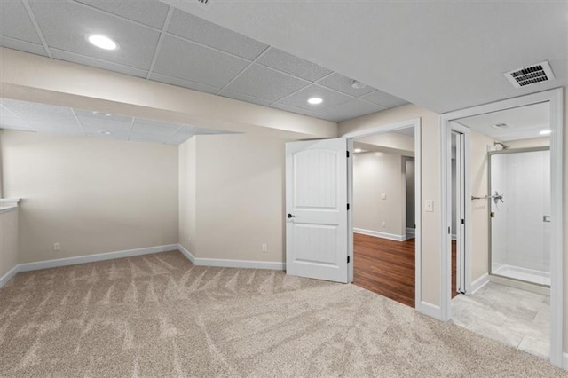 finished basement with carpet, visible vents, baseboards, recessed lighting, and a paneled ceiling