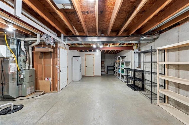 unfinished below grade area featuring white refrigerator with ice dispenser