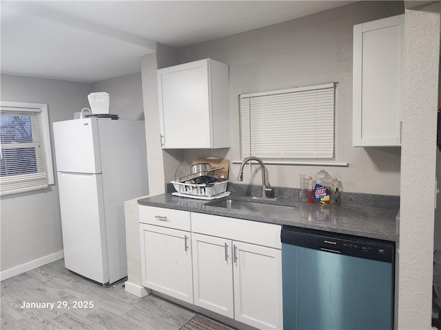 kitchen with sink, stainless steel dishwasher, white cabinets, and white refrigerator