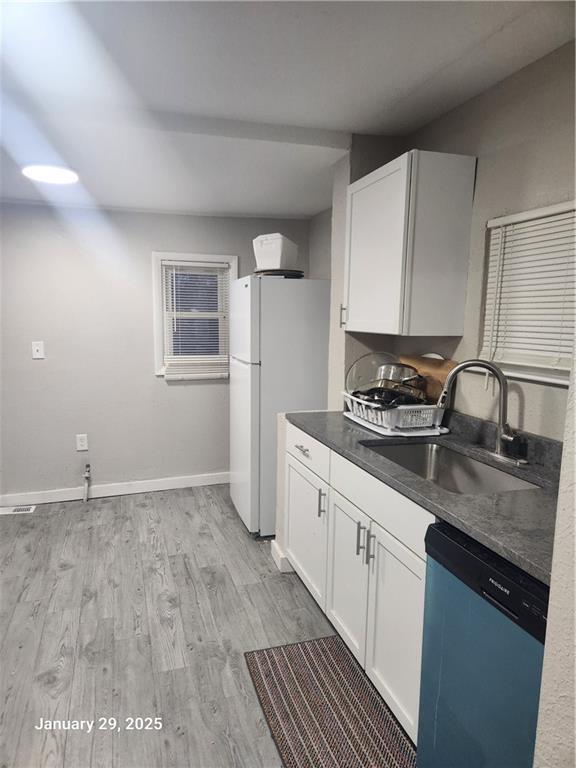 kitchen featuring white cabinetry, dishwasher, sink, white refrigerator, and light hardwood / wood-style flooring