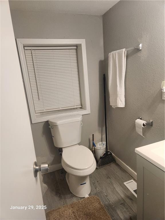 bathroom with hardwood / wood-style flooring, vanity, and toilet