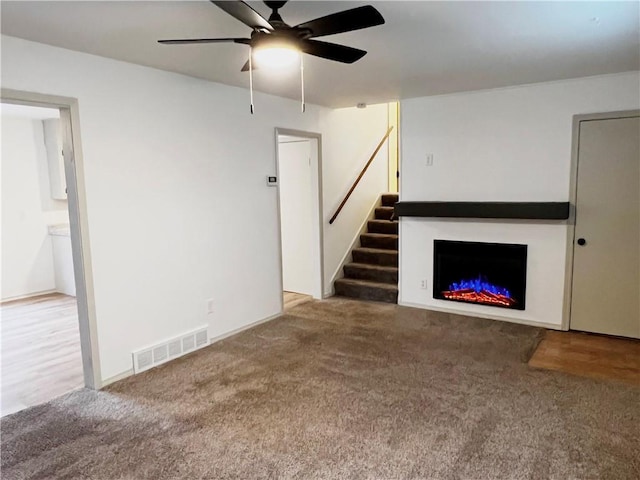 unfurnished living room featuring carpet flooring and ceiling fan