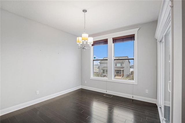 unfurnished dining area featuring a notable chandelier and dark hardwood / wood-style floors