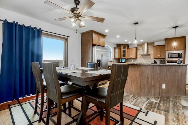 dining area with light wood finished floors, a ceiling fan, and recessed lighting