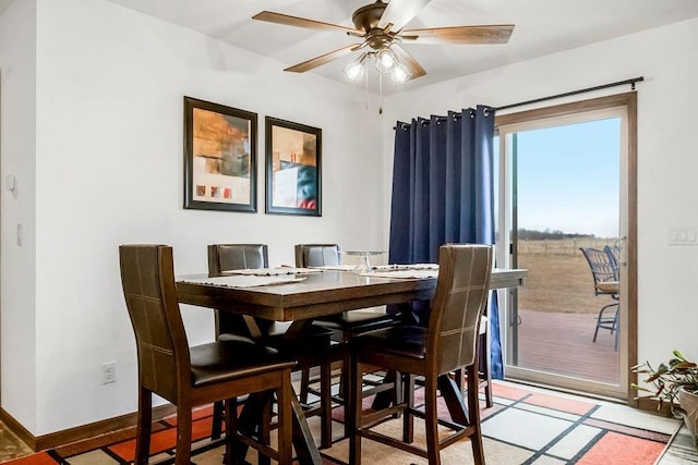 dining space with ceiling fan and baseboards