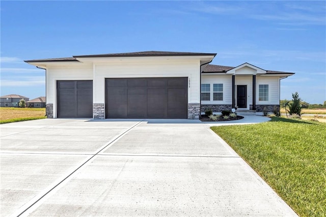 prairie-style home with a garage and a front lawn