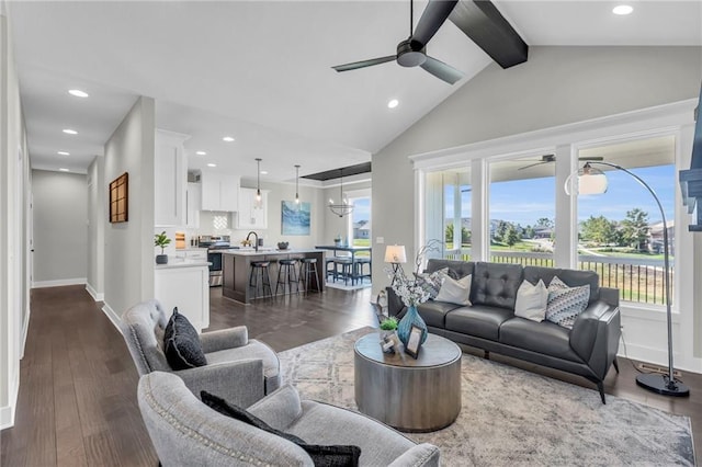 living room with sink, lofted ceiling with beams, dark hardwood / wood-style floors, and ceiling fan