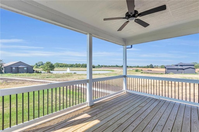 wooden terrace featuring a water view and ceiling fan