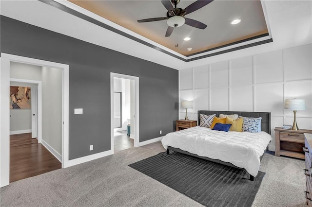 bedroom featuring carpet flooring, a tray ceiling, and ensuite bath