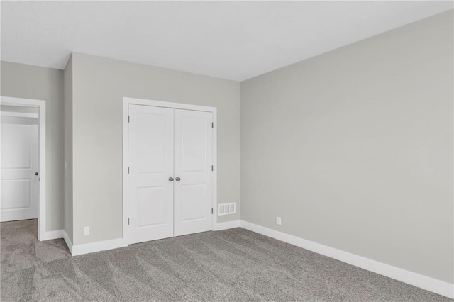 unfurnished bedroom with light colored carpet and a closet