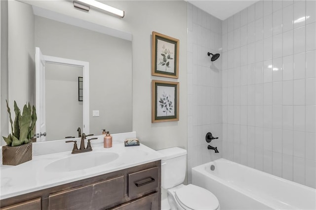 full bathroom with vanity, tiled shower / bath, and toilet