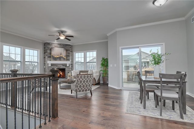 interior space with dark hardwood / wood-style flooring, a fireplace, ornamental molding, and ceiling fan