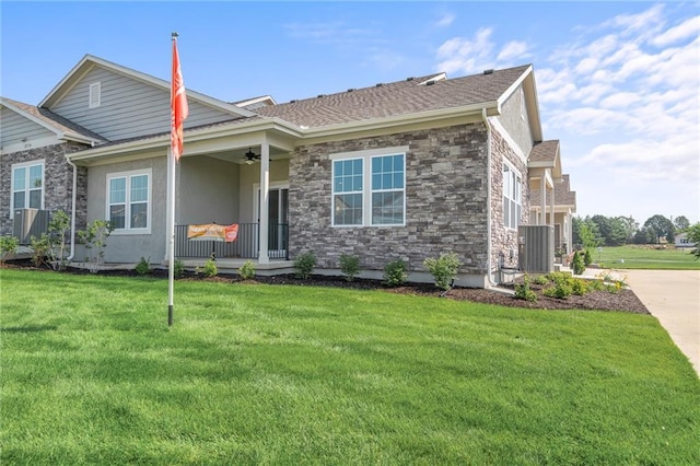 view of front of house featuring ceiling fan, central air condition unit, covered porch, and a front lawn