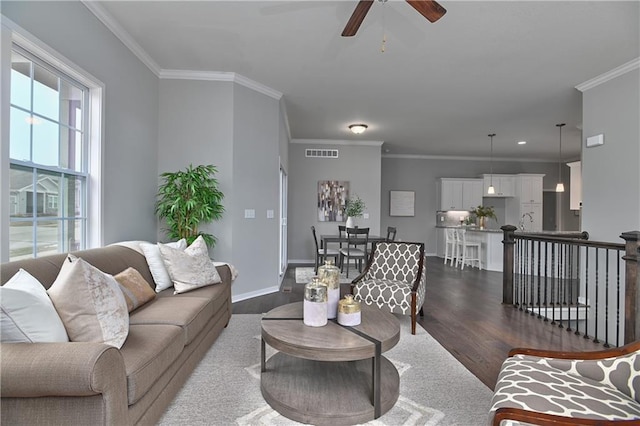 living room with crown molding, sink, ceiling fan, and dark hardwood / wood-style flooring