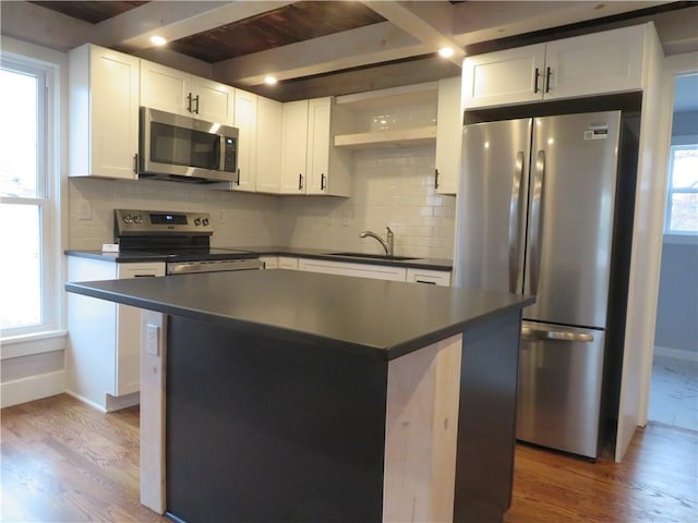 kitchen featuring sink, stainless steel appliances, a center island, and white cabinets