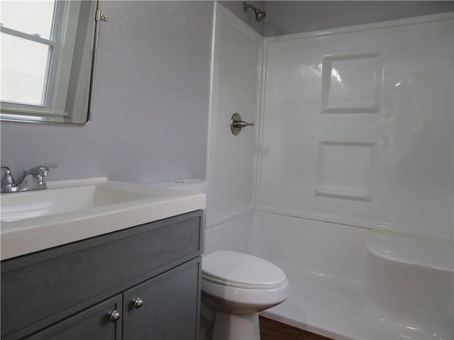 bathroom with vanity, a shower, and toilet